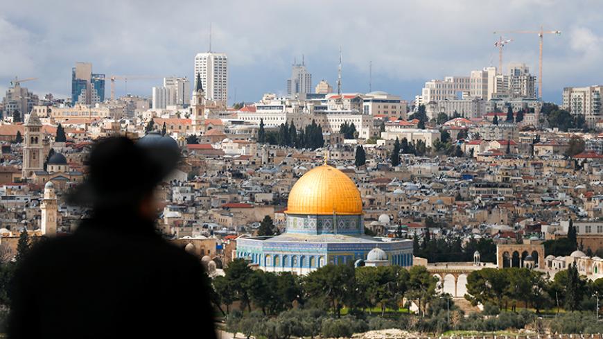 An ultra-Orthodox Jewish man is seen in the foreground as the Dome of the Rock, located in Jerusalem's Old City on the compound known to Muslims as Noble Sanctuary and to Jews as Temple Mount, is seen in the background February 15, 2017. REUTERS/Ammar Awad - RTSYSCA