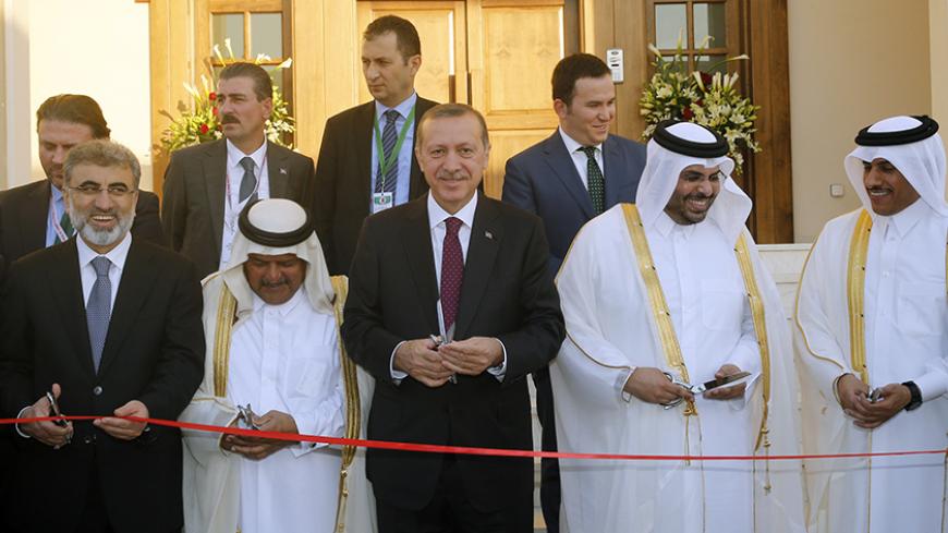 Turkey's Prime Minister Tayyip Erdogan (C) cuts the ribbon during the opening ceremony of the new building of the Turkish Embassy in Doha December 4, 2013. REUTERS/Mohammed Dabbous (QATAR - Tags: POLITICS) - RTX163FZ