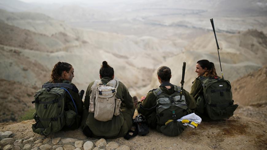 Israeli soldiers of the Caracal battalion rest after finishing a 20-kilometre march in Israel's Negev desert, near Kibbutz Sde Boker, marking the end of their training, May 29, 2014. The "Caracal" battalion, two-thirds of whose members are women, was established in 2004 with the purpose of incorporating female soldiers in combat units. The main mission of Caracal is routine patrols on Israel's border with Egypt to intercept infiltrators and smuggling from the Sinai desert. REUTERS/Amir Cohen (ISRAEL - Tags: