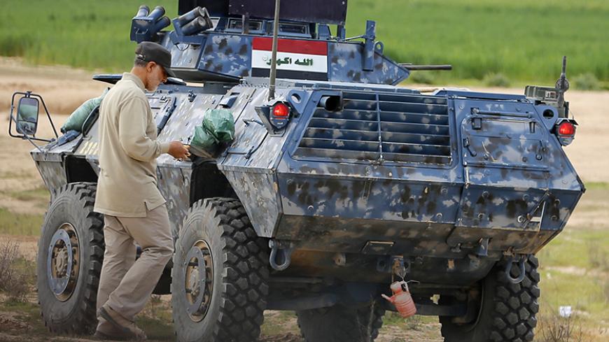 Iranian Revolutionary Guard Commander Qassem Soleimani walks near an armoured vehicle at the frontline during offensive operations against Islamic State militants in the town of Tal Ksaiba in Salahuddin province March 8, 2015. Picture taken March 8, 2015.   REUTERS/Stringer (IRAQ - Tags: CIVIL UNREST CONFLICT POLITICS) - RTR4TTZW