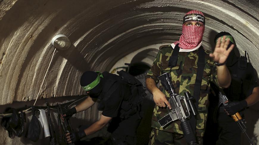 A Palestinian fighter from the Izz el-Deen al-Qassam Brigades, the armed wing of the Hamas movement, gestures inside an underground tunnel in Gaza in this August 18, 2014 file photo.  REUTERS/Mohammed Salem/Files - RTX2AF59