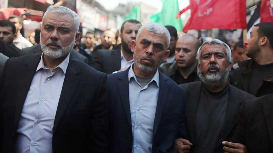 Hamas Gaza Chief Yehya Al-Sinwar (C) and Hamas leader Ismail Haniyeh (L) take part in the funeral of senior militant Mazen Fuqaha in Gaza City March 25, 2017. REUTERS/Mohammed Salem - RTX32NQR
