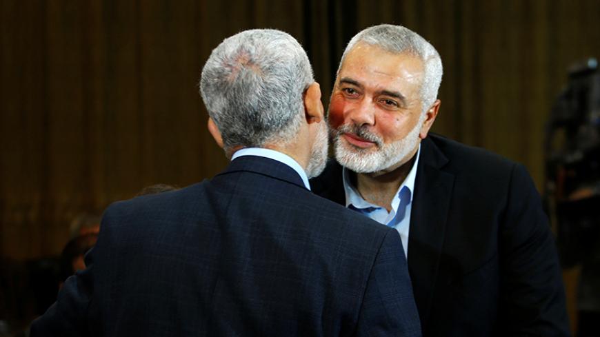 Hamas leader Ismail Haniyeh (R) kisses Hamas Gaza Chief Yehya Al-Sinwar during a ceremony announcing a new policy document, in Gaza City May 1, 2017. REUTERS/Mohammed Salem - RTS14OXA