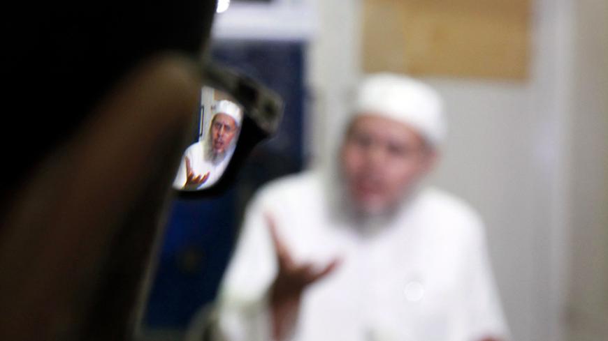 Abdel Akhir Hammad, spiritual leader of the formerly militant group al-Gamaa al-Islamiya, is reflected in a person's spectacles during an interview with Reuters in Assiut July 13, 2013. Reconciliation between Egypt's Islamist and secular politicians is impossible unless deposed President Mohamed Mursi is reinstated, leading Islamist Hammad told Reuters, but played down any suggestion that his movement might return to its violent past. Picture taken July 13. To match Interview EGYPT-PROTESTS/ISLAMISTS   REUT