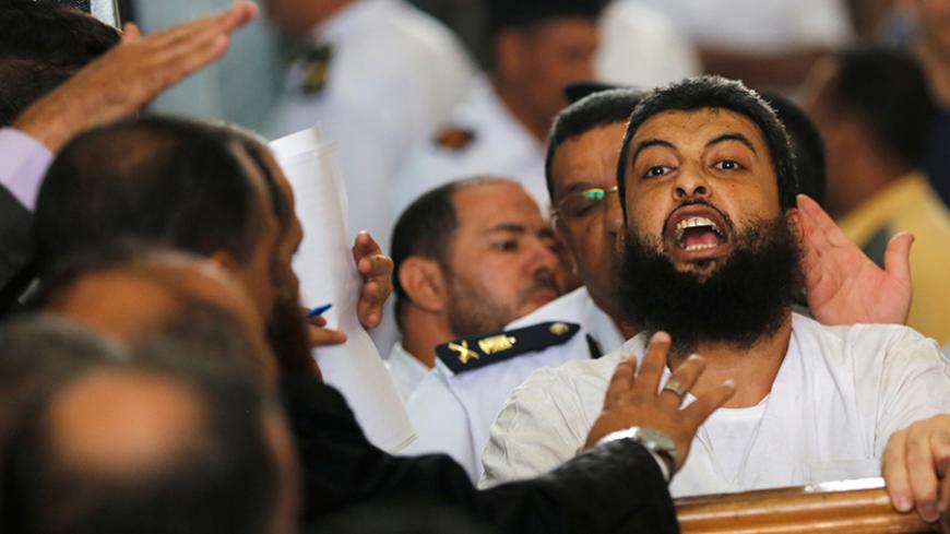 A defendant, who is a member of the Muslim Brotherhood, shouts solgans against the Interior Ministery during the trial of brotherhood members for their armed sit-in at Rabaa square, at a court on the outskirts of Cairo, Egypt May 31, 2016. REUTERS/Amr Abdallah Dalsh - RTX2F12V