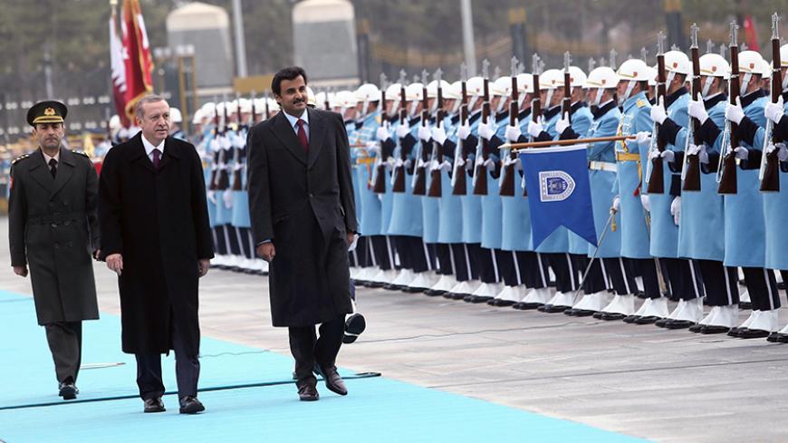 Qatari Crown Prince Sheikh Tamim bin Hamad bin Khalifa al-Thani (R) and Turkish President Recep Tayyip Erdogan (2ndL), walk past a guard of honor during an official welcoming ceremony prior to their meeting at the presidential palace in Ankara, Turkey, on December 19, 2014. AFP PHOTO / ADEM ALTAN        (Photo credit should read ADEM ALTAN/AFP/Getty Images)