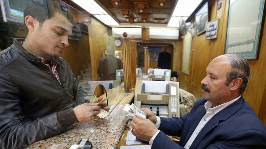 A customer exchanges U.S. dollars to Egyptian pounds in a foreign exchange office in central Cairo, Egypt, March 7, 2017. REUTERS/Mohamed Abd El Ghany - RTS11T3C