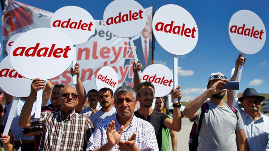 Supporters of the main opposition Republican People's Party (CHP) hold placards as they walk with the party's leader Kemal Kilicdaroglu (not pictured) during the second day of a protest, dubbed a "justice march", against the detention of CHP lawmaker Enis Berberoglu, in Saray near Ankara, Turkey June 16, 2017. Placards read "Justice". REUTERS/Osman Orsal - RTS17CJ8