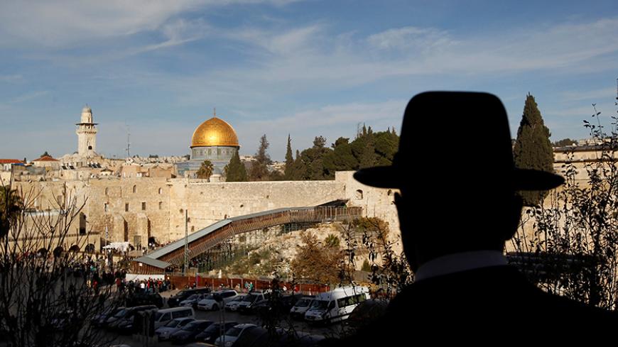 An ultra-Orthodox Jewish man stands at a view-point overlooking a wooden ramp (C) leading up from Judaism's Western Wall to the sacred compound known to Muslims as the Noble Sanctuary and to Jews as Temple Mount, where the al-Aqsa mosque and the Dome of the Rock shrine stand, in Jerusalem's Old City December 12, 2011. REUTERS/Ronen Zvulun/File Photo - RTSS5BJ