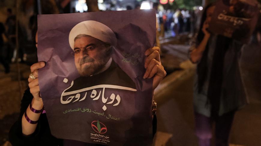 A supporter of Iranian president Hassan Rouhani holds his poster as she celebrates his victory in the presidential election, in Tehran, Iran, May 20, 2017. TIMA via REUTERS ATTENTION EDITORS - THIS IMAGE WAS PROVIDED BY A THIRD PARTY. FOR EDITORIAL USE ONLY. - RTX36R4M