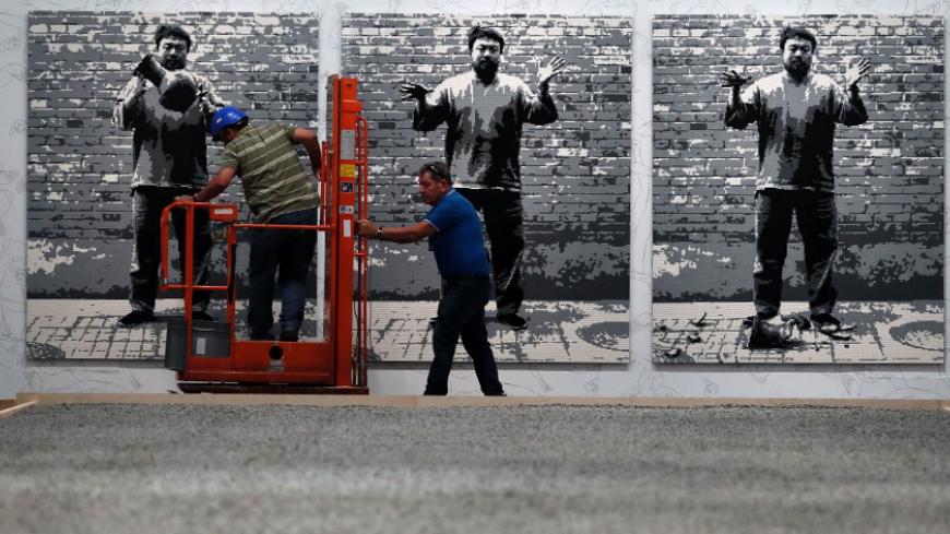 Workers pass art work by Chinese artist Ai Weiwei titled "Dropping a Han Dynasty Urn" (2016) which is made with Lego bricks on the eve of the opening of his new exhibition "Maybe, Maybe Not" at the Israel Museum in Jerusalem on June 1, 2017.  / AFP PHOTO / THOMAS COEX / RESTRICTED TO EDITORIAL USE - MANDATORY MENTION OF THE ARTIST UPON PUBLICATION - TO ILLUSTRATE THE EVENT AS SPECIFIED IN THE CAPTION        (Photo credit should read THOMAS COEX/AFP/Getty Images)