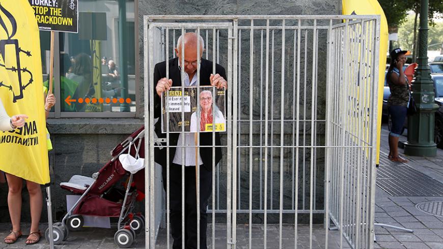 Amnesty International Belgium's Director Philippe Hensmans poses in a cage in front of the Turkish embassy in Brussels to protest against the detention of his Turkish counterpart Idil Eser, Belgium, July 10, 2017.  REUTERS/Francois Lenoir TPX IMAGES OF THE DAY - RTX3ATNW