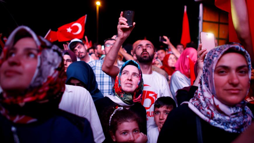 People listen to the speech of Turkey's President Tayyip Erdogan during a ceremony marking the first anniversary of the attempted coup at the Bosphorus Bridge in Istanbul, Turkey, July 15, 2017. REUTERS/Osman Orsal     TPX IMAGES OF THE DAY - RTX3BLUL