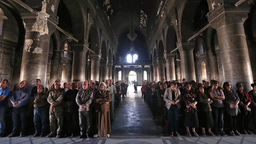TOPSHOT - Iraqi Christians attend a mass at the Church of the Immaculate Conception on July 24, 2017  in the predominantly Christian Iraqi town of Qaraqosh (also known as Hamdaniya), some 30 kilometres from Mosul. 
Cardinal Philippe Barbarin, who was split between "sadness" and "hope", attended a mass for the "renaissance" in Qaraqosh, which housed one of the largest Christian communities in Iraq before its capture by the Islamic State group . / AFP PHOTO / SAFIN HAMED / The erroneous date appearing in the 