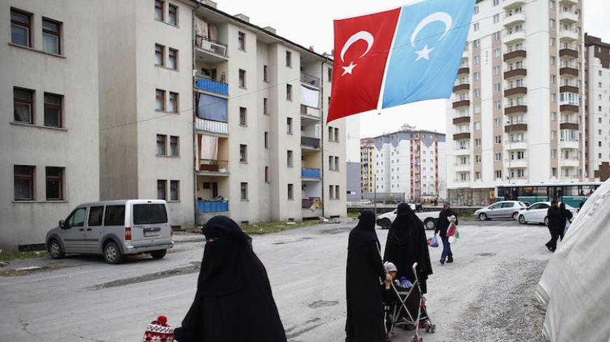 Uighur refugee women walk where they are housed in a gated complex in the central city of Kayseri, Turkey, February 11, 2015. Thousands of members of China's Turkic language-speaking Muslim ethnic minority have reached Turkey, mostly since last year, infuriating Beijing, which accuses Ankara of helping its citizens flee unlawfully. Turkish officials deny playing any direct role in assisting the flight. Picture taken February 11, 2015. To match Insight TURKEY-CHINA/UIGHURS REUTERS/Umit Bektas - RTX1LZ2I