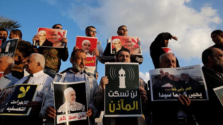 Supporters of Sheikh Raed Salah, head of Islamic Movement's northern branch, protest in the Israeli-Arab town of Umm el-Fahm against the initial approval of a bill to enforce lowering the volume of mosque loudspeakers calling worshippers to prayer, November 17, 2016. The placards reads " The mosque's call to prayer will not be silenced" REUTERS/Ammar Awad - RTX2U4XL