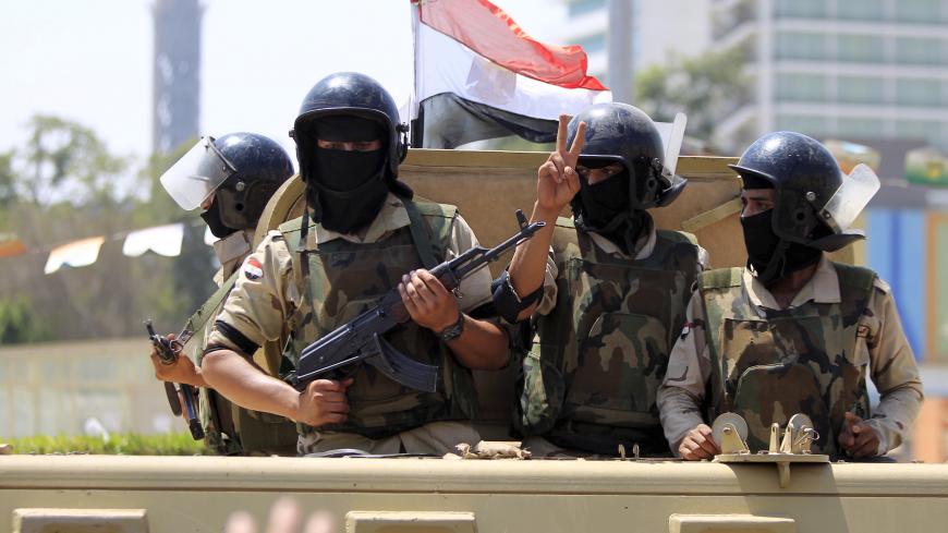 Army soldiers are seen as their convoy passes by Tahrir square to secure central Cairo as Egyptians celebrate an extension of the Suez Canal, in Cairo, Egypt, August 6, 2015. Egypt will open an expansion to the Suez Canal to great fanfare on Thursday, the centrepiece of President Abdel Fattah al-Sisi's plans to revitalise the country's economy after years of damaging political turmoil. REUTERS/Mohamed Abd El Ghany - GF20000015455