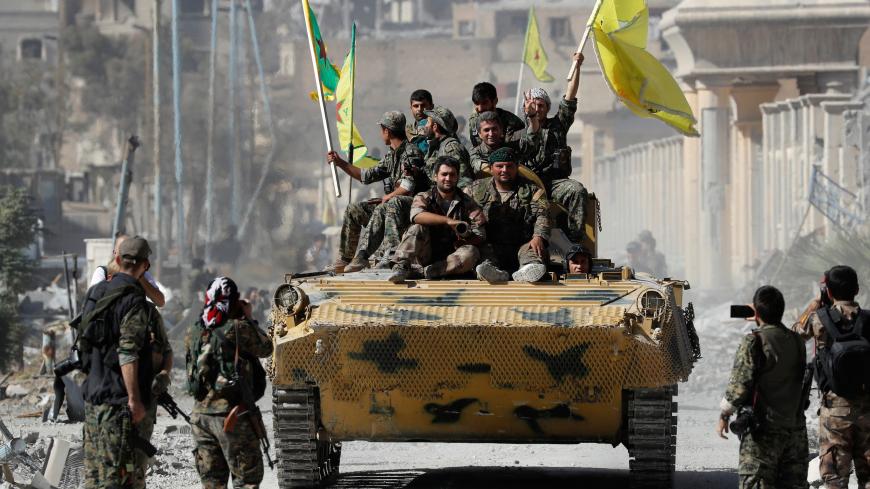Fighters of Syrian Democratic Forces ride atop of an armoured vehicle after Raqqa was liberated from the Islamic State militants, in Raqqa, Syria October 17, 2017.      REUTERS/Erik De Castro - RC16D09535E0
