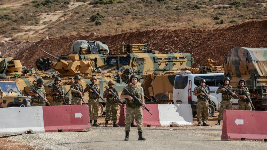 Turkish soldiers stand near armoured vehicles during a demonstration in support of the Turkish army's Idlib operation near the Turkey-Syria border near Reyhanli, Hatay, on October 10, 2017.
The Turkish army has launched a reconnaissance mission in Syria's largely jihadist-controlled northwestern Idlib province in a bid to create a de-escalation zone, the military said on October 9.  / AFP PHOTO / ILYAS AKENGIN        (Photo credit should read ILYAS AKENGIN/AFP/Getty Images)