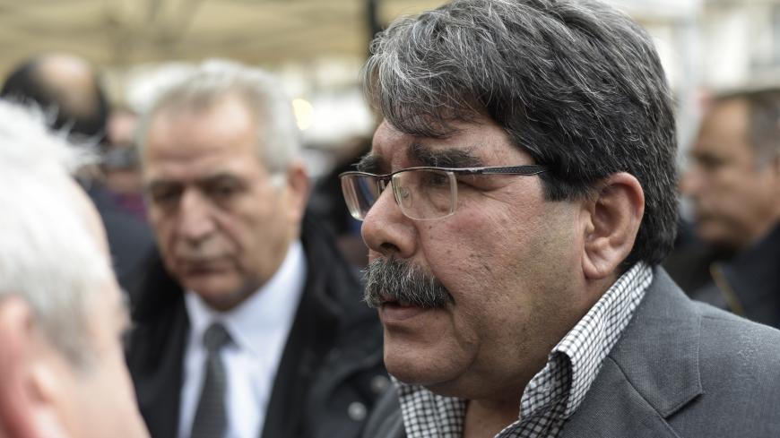 Salih Muslim Muhammad  chairman of the PYD, the Syrian branch of the PKK answers journalists' questions as he arrives to pay tribute to the victims of the attacks claimed by Islamic State which killed at least 129 people and left more than 350 injured, on November 17, 2015 in front of the Bataclan theatrein Paris. AFP PHOTO / ADRIEN MORLENT        (Photo credit should read ADRIEN MORLENT/AFP/Getty Images)
