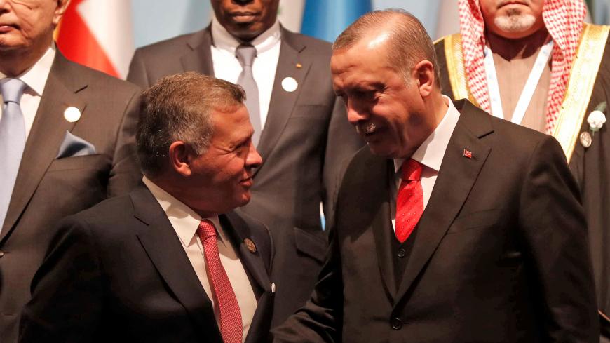 Turkish President Tayyip Erdogan chats with Jordan's King Abdullah as they pose for a group photo during an extraordinary meeting of the Organisation of Islamic Cooperation (OIC) in Istanbul, Turkey, December 13, 2017. REUTERS/Osman Orsal - RC1F351E9400