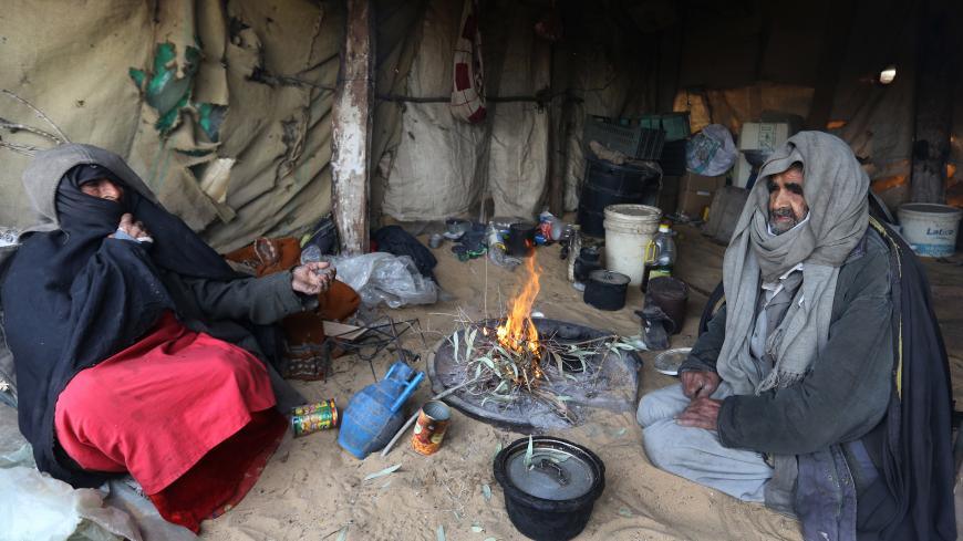 Palestinian Bedouins sit in a tent around woodfire to warm up in a Bedouin area south of Gaza City on January 7, 2015 as a major storm dumped heavy rain, high winds and snowfall on parts of the Middle East. AFP PHOTO/ MAHMUD HAMS        (Photo credit should read MAHMUD HAMS/AFP/Getty Images)