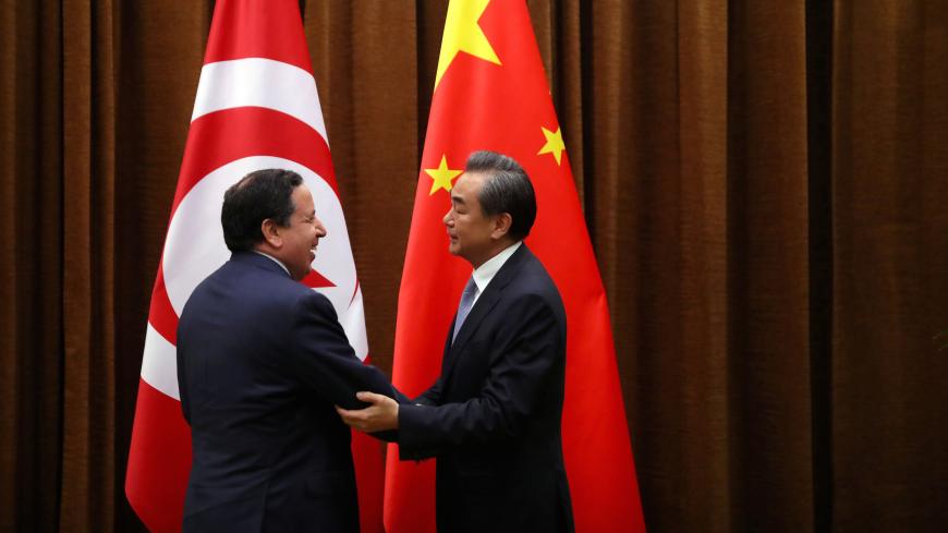 Tunisia's Foreign Minister Khemaies Jhinaoui and Chinese Foreign Minister Wang Yi shake hands as they pose for a photo before a meeting at the Ministry of Foreign Affairs in Beijing, China, July 19, 2017. REUTERS/Mark Schiefelbein/Pool - RC1D72BC9610
