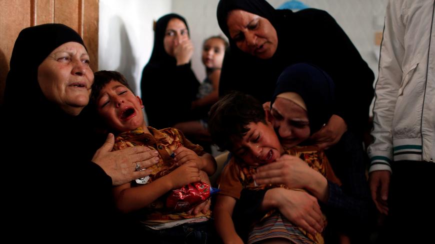 The sons of a Palestinian, who died of wounds he sustained during a protest at the Israel-Gaza border, mourn during their father's funeral in the central Gaza Strip May 25, 2018. REUTERS/Mohammed Salem - RC1886AAD9F0
