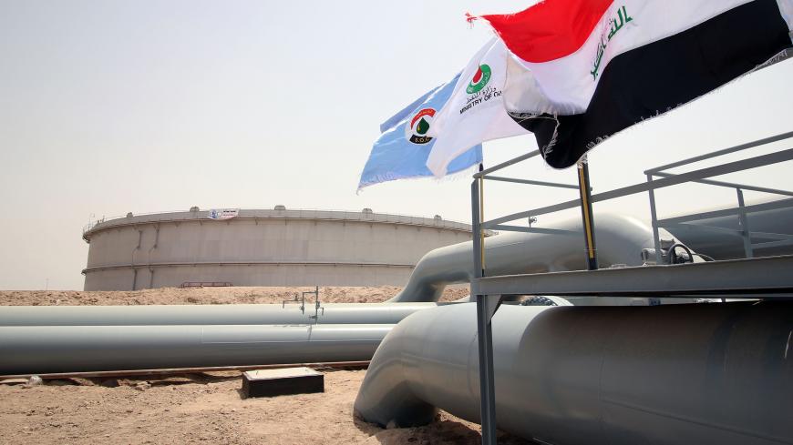 A picture taken on May 31, 2015 shows Iraqi flags fluttering in front of a tank for oil at al-Fao (also spelled al-Faw) storage terminal, located on the al-Fao Peninsula, south of the Iraqi province of Basra. AFP PHOTO / HAIDAR MOHAMMED ALI        (Photo credit should read HAIDAR MOHAMMED ALI/AFP/Getty Images)