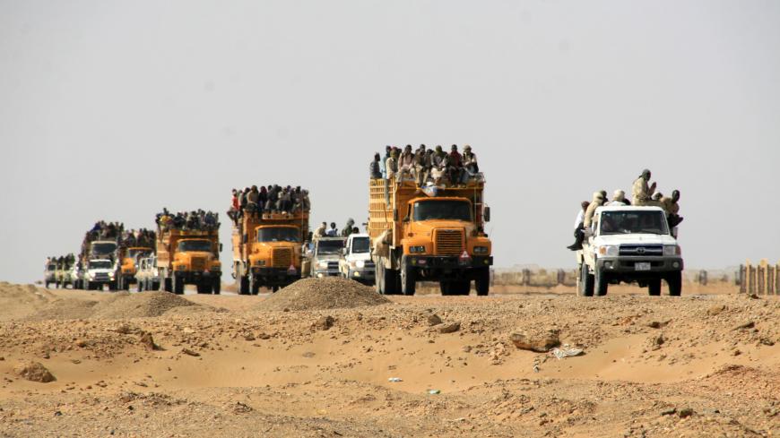 A convoy of vehicles transport illegal immigrants, who were abandoned by traffickers in a remote desert area near the border with Libya, to Dongola May 3, 2014. Sudanese and Libyan forces located the immigrants in the desert area between Sudan and Libya, which is a major route for illegal immigrants trying to escape Sudan's war-torn regions. Many of them transit in Libya before trying to flee to Europe across the Mediterranean Sea. REUTERS/Stringer (SUDAN - Tags: CIVIL UNREST CRIME LAW CONFLICT) - GM1EA540C