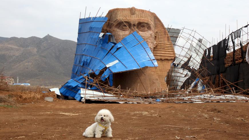 A dog is seen in front of the head of a Sphinx replica, removed from its body, at a theme park which is also a location for the production of movies, television shows and animation shows, on the outskirts of Shijiazhuang, Hebei province, China, April 3, 2016. REUTERS/Stringer ATTENTION EDITORS - THIS PICTURE WAS PROVIDED BY A THIRD PARTY. THIS PICTURE IS DISTRIBUTED EXACTLY AS RECEIVED BY REUTERS, AS A SERVICE TO CLIENTS. CHINA OUT. NO COMMERCIAL OR EDITORIAL SALES IN CHINA.       TPX IMAGES OF THE DAY     