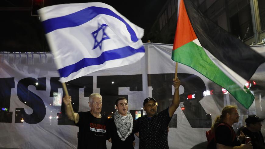 Arab Israelis and their supporters carry a Palestinian (R) and an Israeli flag during a demonstration to protest against the 'Jewish Nation-State Law' in the Israeli coastal city of Tel Aviv on August 11, 2018. The banner in Arabic and Hebrew reads "justice". - The controversial law passed last month declaring the country the nation state of the Jewish people. This has led to concerns that Arab Israelis, who account for some 17.5 percent of Israel's more than eight million population, could now be openly di