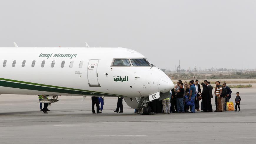 Travellers board an Iraqi Airways plane at Baghdad International airport in Baghdad, October 15, 2014.  REUTERS/Thaier Al-Sudani (IRAQ - Tags: TRANSPORT) - GM1EAAG09IV01