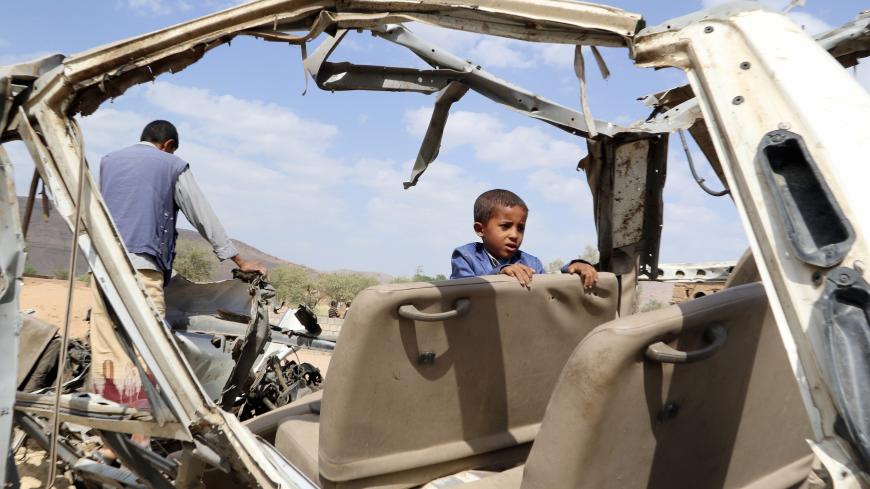 Hafidh Abdullah al-Khawlani, who survived a Saudi-led air strike stands with his father on the wreckage of a bus destroyed by the strike in Saada, Yemen September 4, 2018. His brother was killed by the air strike. Picture taken September 4, 2018. REUTERS/Naif Rahma - RC1FB49D40C0