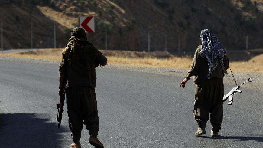 A member of the Kurdistan Workers' Party (PKK) carries an automatic rifle on a road in the Qandil Mountains, the PKK headquarters in northern Iraq, on June 22, 2018. - Hundreds of Iraqi Kurds marched Friday to protest Turkish strikes against the Kurdistan Workers' Party (PKK) after Turkey's President Recep Tayyip Erdogan said Ankara would press an operation against its bases. (Photo by SAFIN HAMED / AFP)        (Photo credit should read SAFIN HAMED/AFP/Getty Images)
