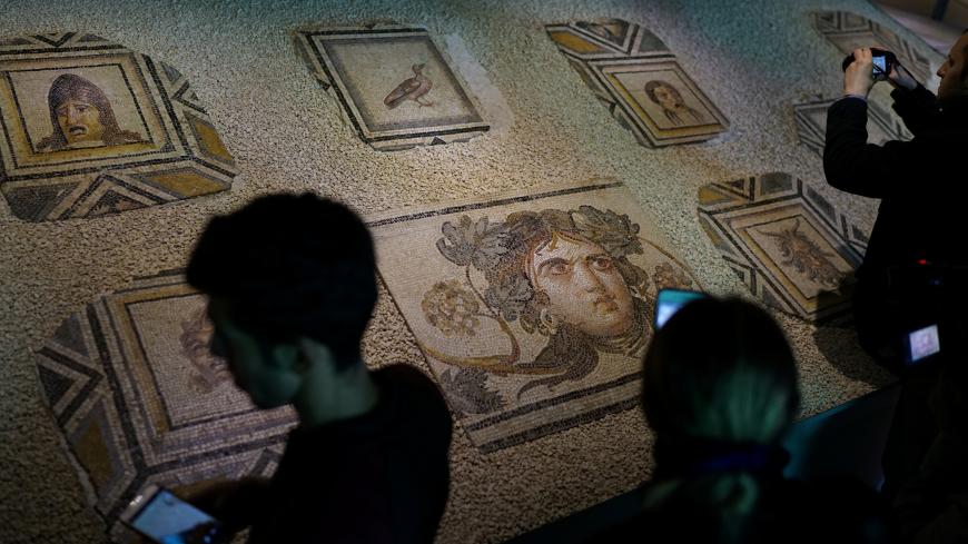 Visitors take pictures of  the missing pieces of the historic "Gypsy Girl" mosaic on display in an exhibition at their origin in Gaziantep, Turkey, December 8, 2018. REUTERS/Umit Bektas - RC1B70413E10