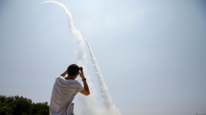 An Israeli man looks on as an Iron Dome launcher fires an interceptor rocket in the southern Israeli city of Ashkelon July 14, 2018  REUTERS/Amir Cohen - RC1E436675A0