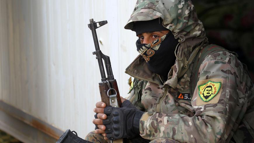 A fighter from the Syrian Democratic Forces (SDF) holds a weapon in the village of Baghouz, Deir Al Zor province, Syria March 17, 2019. REUTERS/Stringer - RC1A73E73120