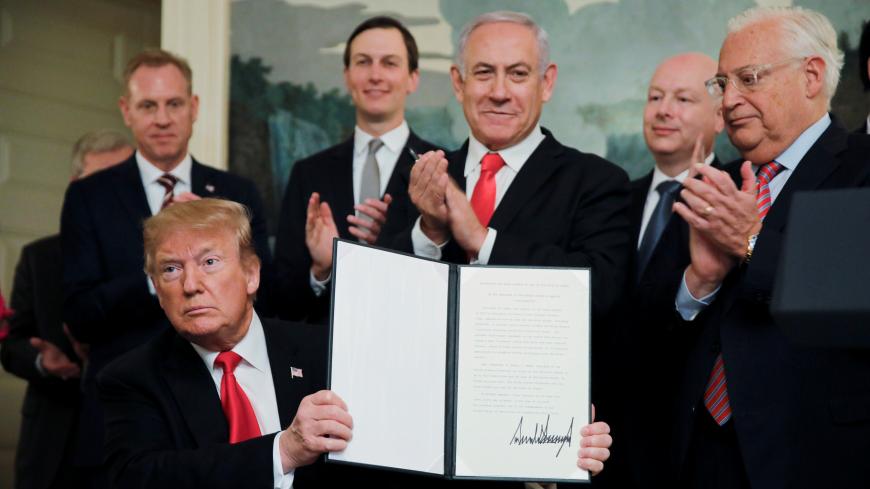 U.S. President Donald Trump holds a proclamation recognizing Israel's sovereignty over the Golan Heights as he is applauded by Israel's Prime Minister Benjamin Netanyahu and others during a ceremony to in the Diplomatic Reception Room at the White House in Washington, U.S., March 25, 2019. REUTERS/Carlos Barria - RC13B9E76220
