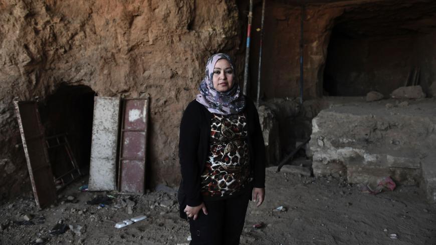 Layla Salih, head of Antiquities for the province of Nineveh, of which Mosul is the capital, poses in front of an underground tunnel in east Mosul on March 6, 2017. 
Two winged bulls dating from the Assyrians empire were found in a labyrinth of narrow underground tunnels dug by the Islamic State group in east Mosul. The impressive maze of tunnels dug by the jihadists to carry out archaeological excavations is located in the heart of the hill that houses the tomb of the Prophet Jonah (Nabi Younes). / AFP PHO