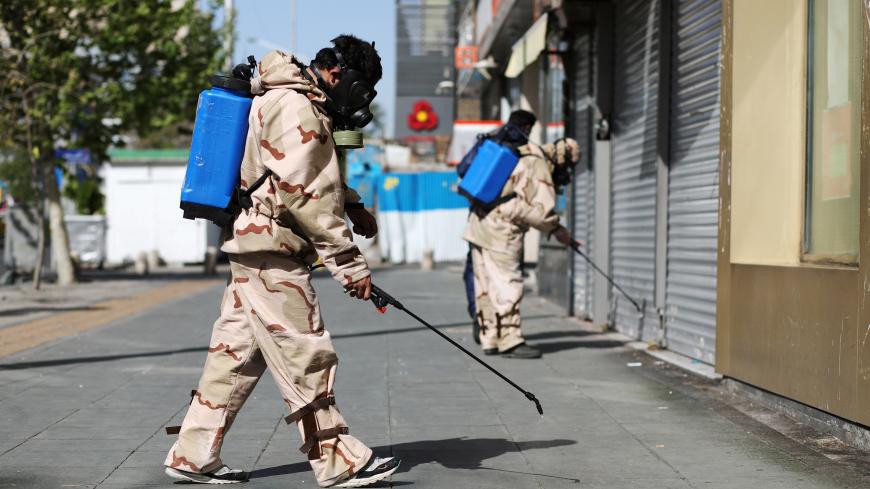 Volunteers from Basij forces wearing protective suits and face masks spray disinfectant in the streets, amid the coronavirus disease (COVID-19) fears, in Tehran, Iran April 3, 2020. WANA (West Asia News Agency)/Ali Khara via REUTERS ATTENTION EDITORS - THIS PICTURE WAS PROVIDED BY A THIRD PARTY - RC2ZWF9FYUHG