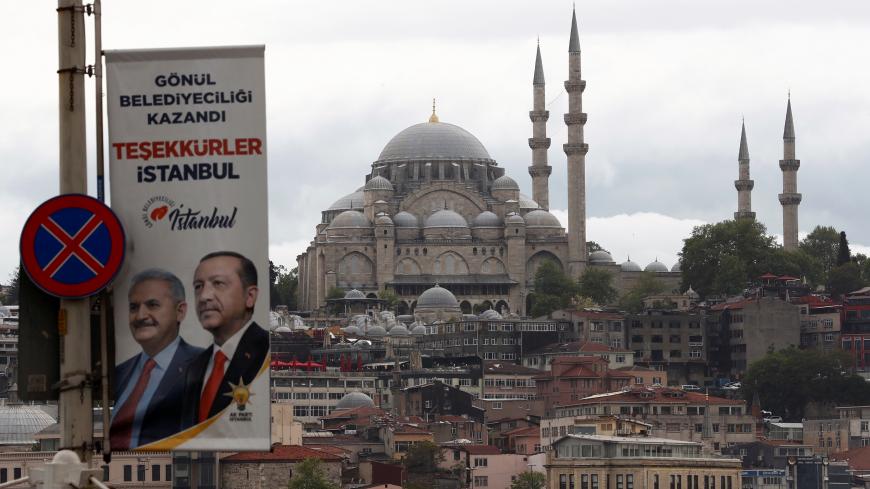 An election banner with the pictures of Turkish President Tayyip Erdogan and AK Party mayoral candidate Binali Yildirim is seen over the Galata bridge in Istanbul, Turkey, May 7, 2019. REUTERS/Murad Sezer - RC155DF5D450