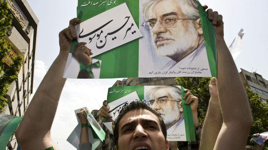 A man holds a poster of Iranian presidential candidate Mir Hossein Mousavi during a rally in support of Mousavi, after Friday prayers in Tehran May 29, 2009. Iranians vote on June 12 in an election that pits hardline President Mahmoud Ahmadinejad against two moderate challengers and one fellow conservative.    REUTERS/Raheb Homavandi (IRAN POLITICS ELECTIONS) - GM1E55T1JXM01