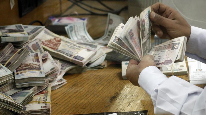 An employee counts money at a bank in Cairo September 4, 2014.  REUTERS/Asmaa Waguih (EGYPT - Tags: BUSINESS) - GM1EA941TDY01