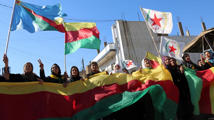 Kurdish women hold flags of the Kurdish People's Protection Units (YPG) political wing, the Democratic Union Party (PYD), and banners during a demonstration against the exclusion of Syrian-Kurds from the Geneva talks in the northeastern Syrian city of Qamishli on February 4, 2016.  
The talks in Geneva are the latest bid to end Syria's conflict, nearly five years after it began in March 2011 with anti-government protests. But they have stalled over the make-up of the opposition as well as its insistence tha