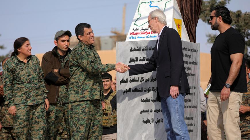 Mazloum Kobani, SDF's commander in chief, shakes hands with the advisor for the US Department of State in northern Syria William Robak, at al-Omar oil field in Deir Al Zor, Syria March 23, 2019. REUTERS/Rodi Said - RC142AE67C90