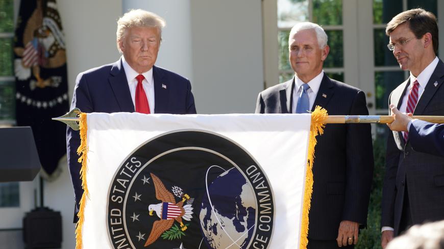 U.S. President Donald Trump stands behind a U.S. Space Command flag with Vice President Mike Pence and Defense Secretary Mark Esper at an event to officially launch the United States Space Command in the Rose Garden of the White House in Washington, U.S., August 29, 2019. REUTERS/Kevin Lamarque - RC1E707D9440