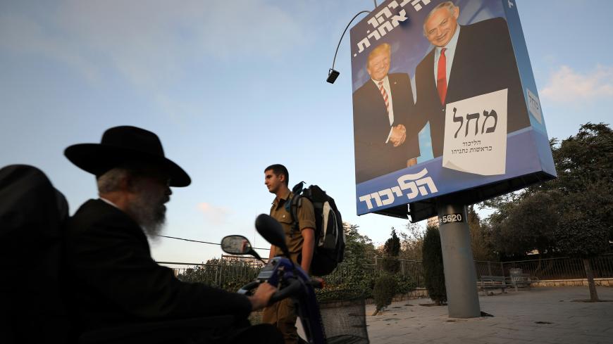 Ultra-Orthodox Jewish men walk past a Likud party election campaign banner depicting Israeli Prime Minister Benjamin Netanyahu and U.S. President Donald Trump in Jerusalem September 11, 2019. REUTERS/Ammar Awad - RC1A12196B30