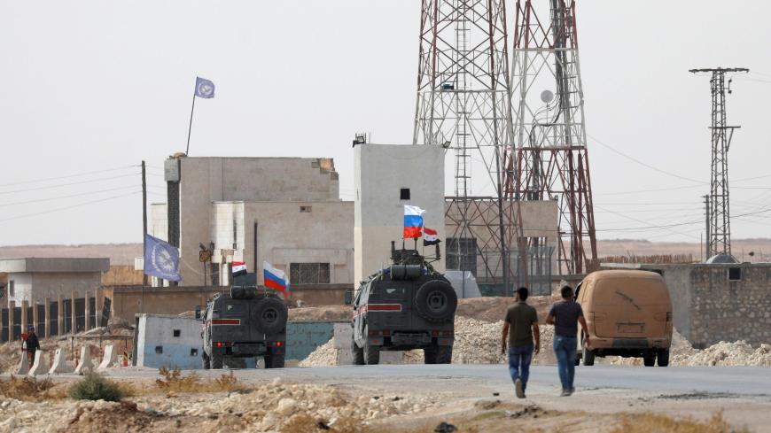 Russian and Syrian national flags flutter on military vehicles near Manbij, Syria October 15, 2019. REUTERS/Omar Sanadiki - RC134A208F00