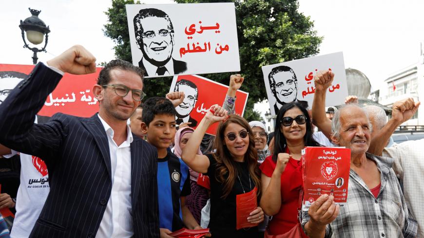 Saloua Samoui, the wife of detained Tunisian media mogul and presidential candidate Nabil Karoui, stands with supporters as she distributes election leaflets for Karoui's Heart of Tunisia party ahead of the upcoming parliamentary elections in Tunis, Tunisia October 3, 2019. Picture taken October 3, 2019. REUTERS/Zoubeir Souissi - RC1A9FEF8FC0